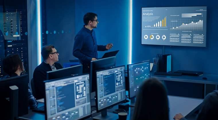 Team of Professional IT Developers Have a Meeting, Speaker Shows Growth Data