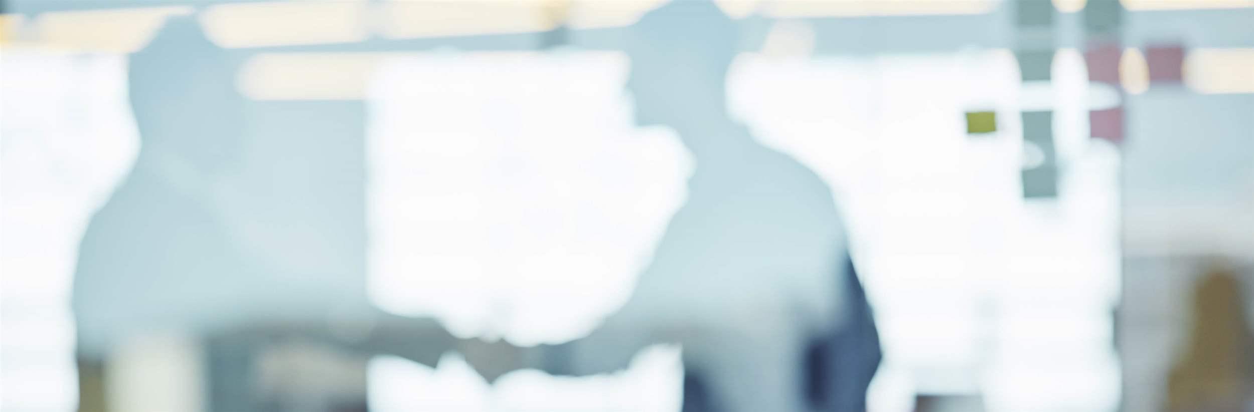 Through the glass shot of a people working in an office