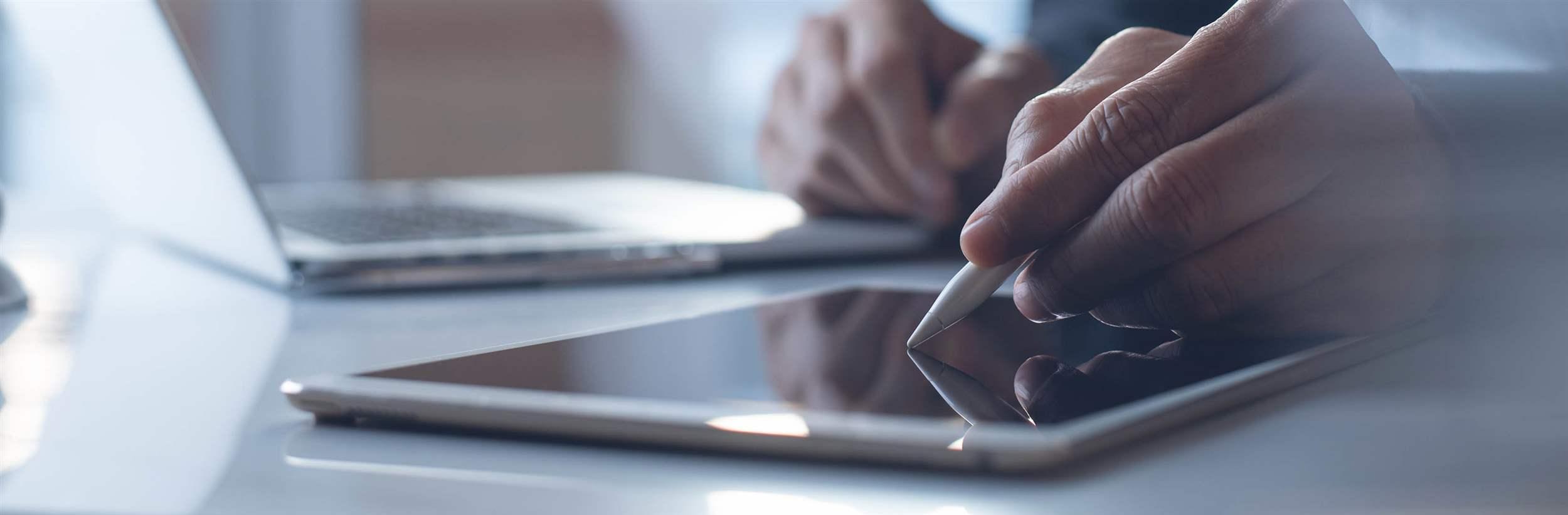 Business man taking note via digital notepad application, graphic designer using electronic pen on digital tablet, working on laptop computer on table in modern office, close up