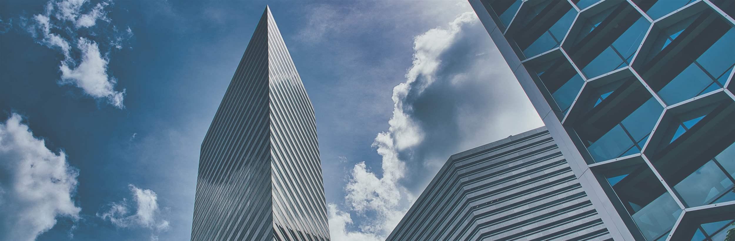 Panoramic and perspective wide angle view to steel light blue background of glass high rise building skyscraper commercial modern city of future.