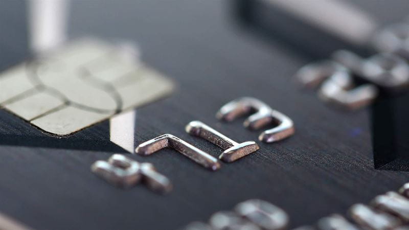 Embossed chipped credit card lying on silver keyboard closeup. Retail sale funds savings atm stash debt visa bankcard customer security pin code management trade earn investment discount concept