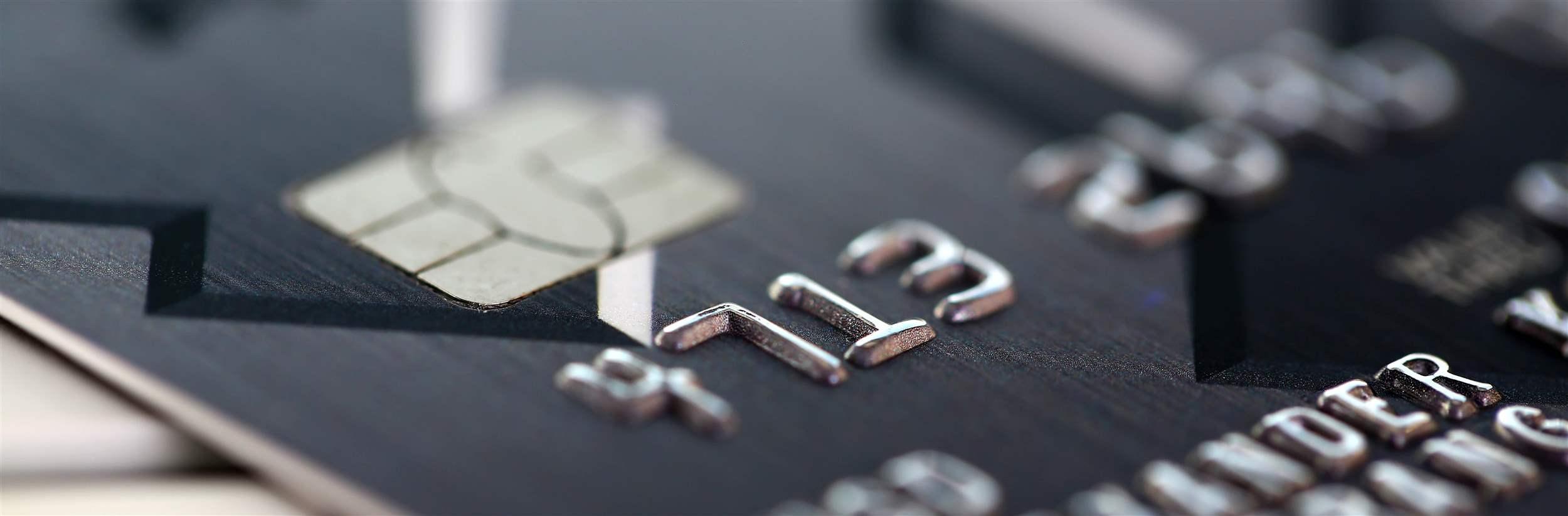Embossed chipped credit card lying on silver keyboard closeup. Retail sale funds savings atm stash debt visa bankcard customer security pin code management trade earn investment discount concept