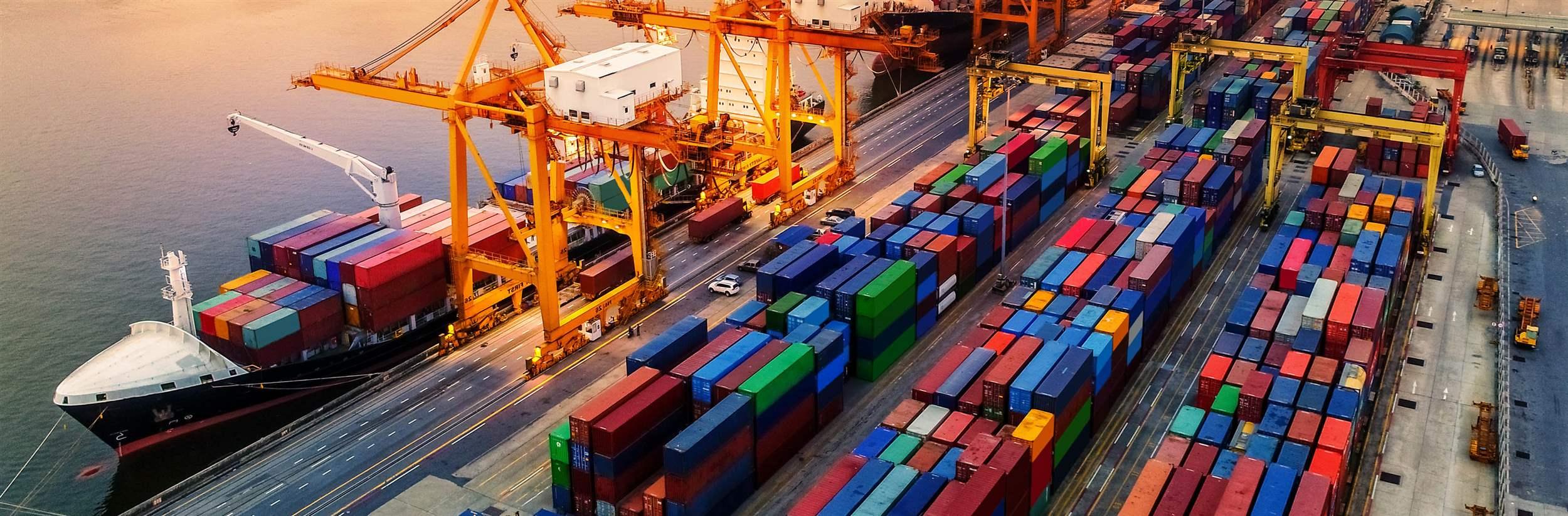 Logistics and transportation of Container Cargo ship and Cargo plane with working crane bridge in shipyard at sunrise, logistic import export and transport industry background