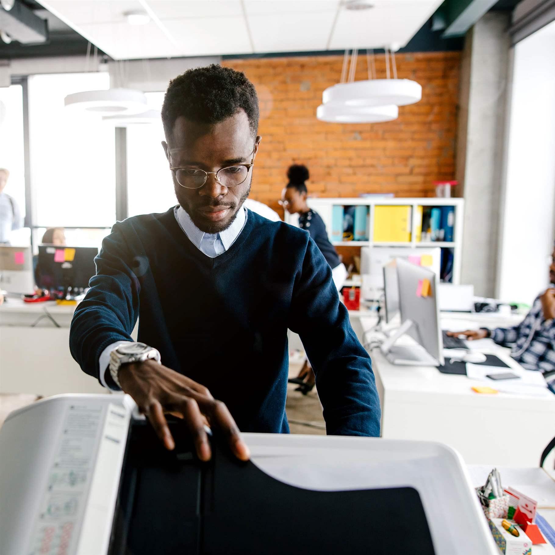 closeup portrait of black worker is printing a file , document in the office room. Accounting concept