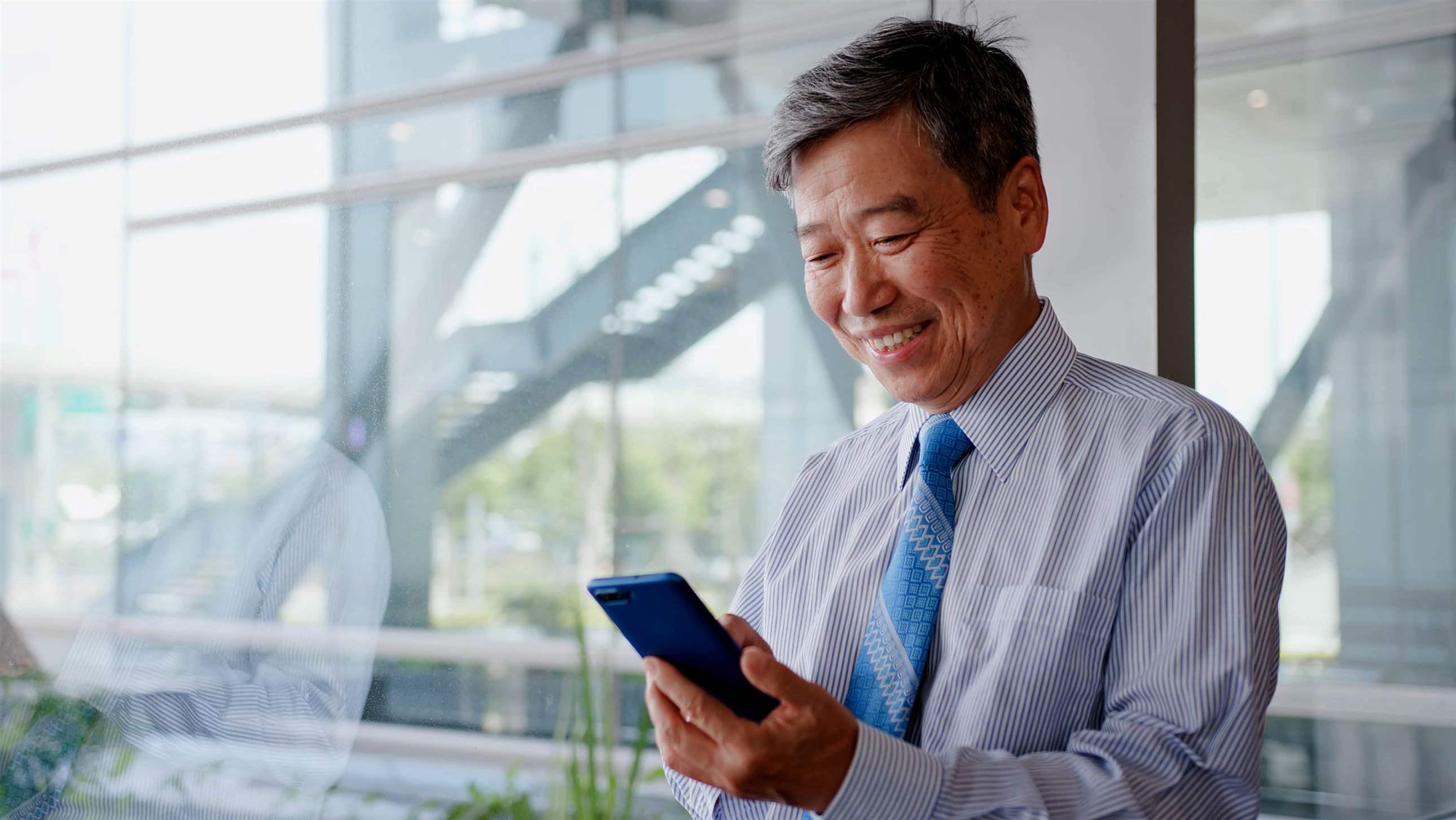 old businessman smile happily and use phone
