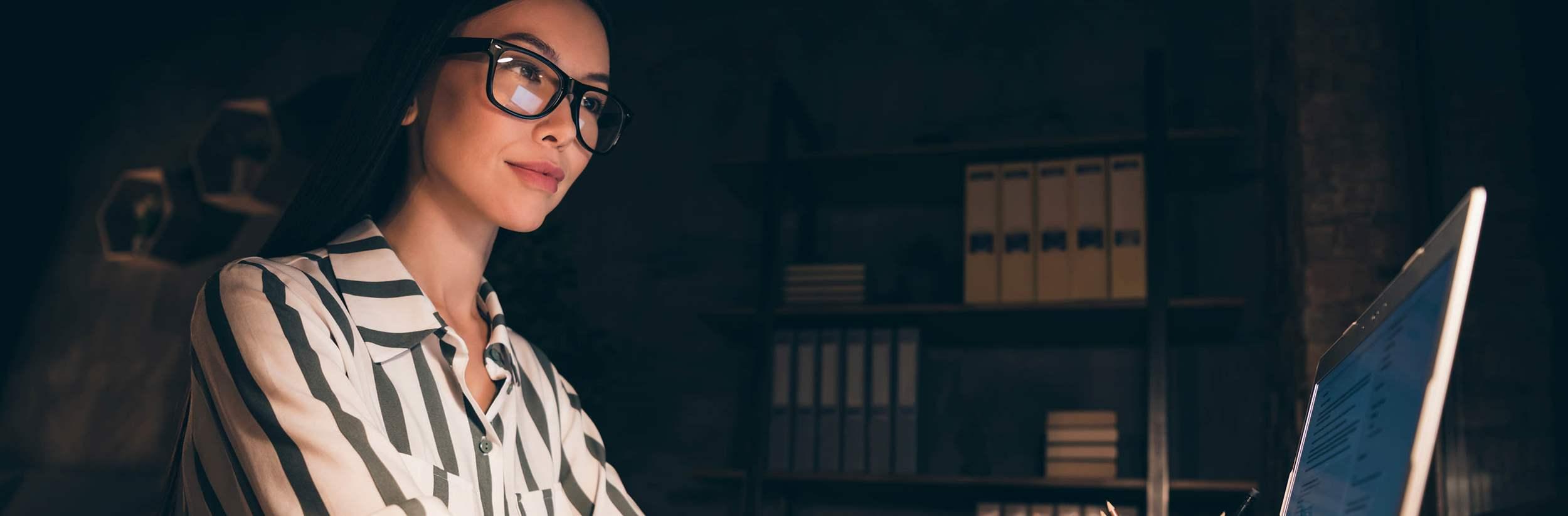 Profile photo of amazing asian business lady look notebook screen, table write new project creative idea hands on keyboard sit chair wear striped shirt night dark modern office