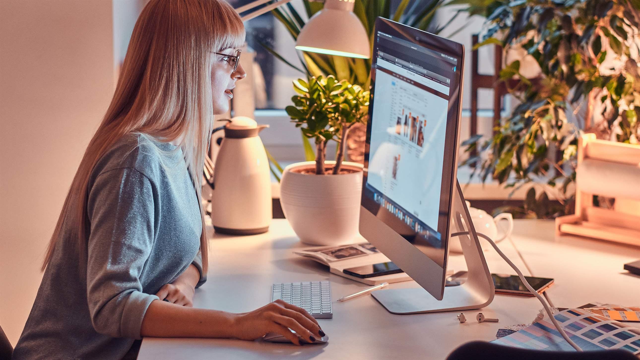 woman in glasses is working on computer at nice office.