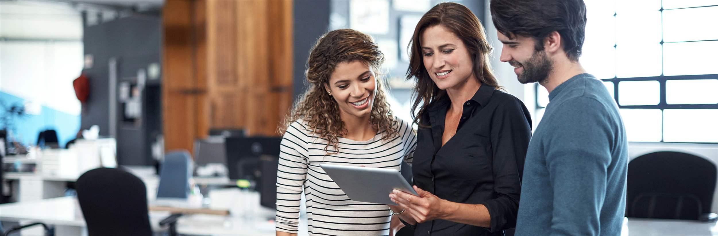 Cropped shot of three colleagues looking at a tablet in the office