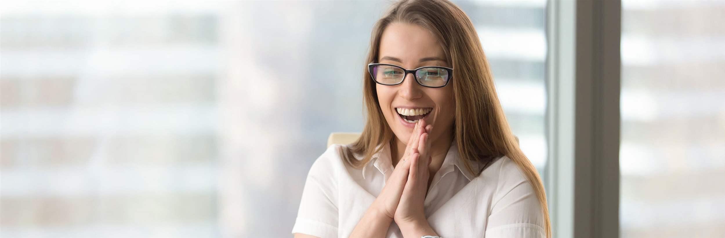 Happy businesswoman laughing with joy at workplace, gladly looking at laptop screen, feeling excited about online win, watching funny video on computer, enjoying positive good news in internet