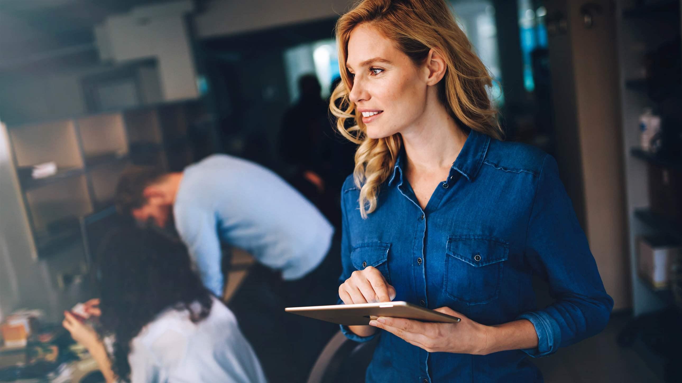 Beautiful blond business woman using tablet in modern office