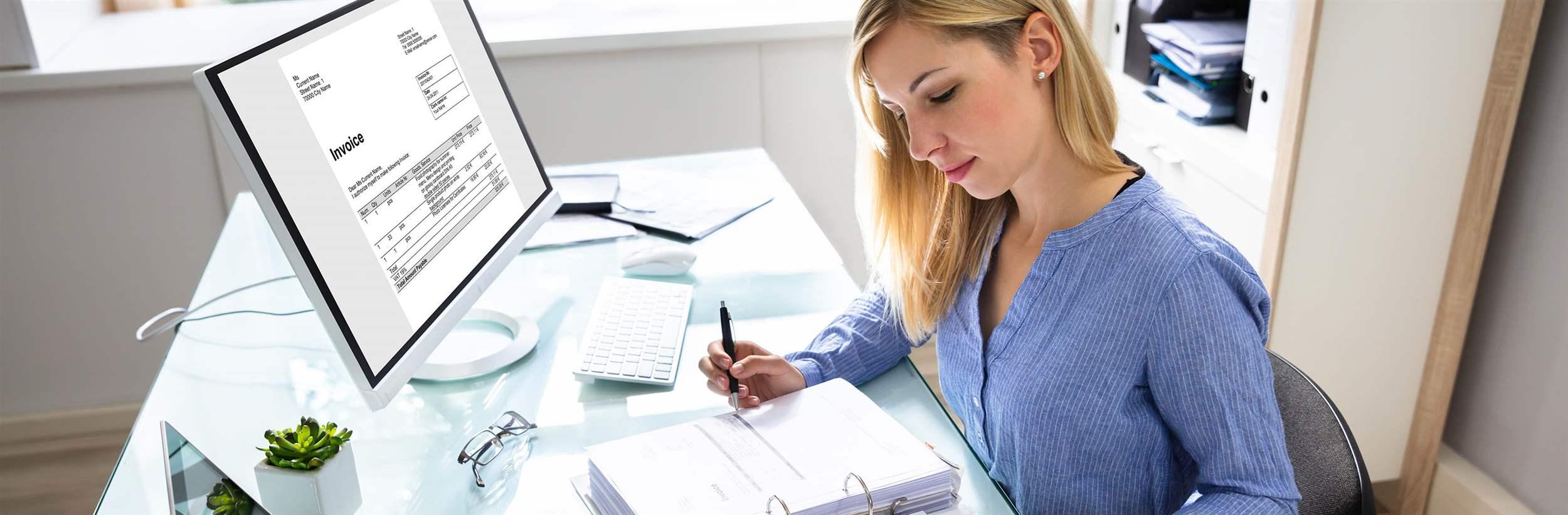 Young Businesswoman Calculating Bill With Computer And Laptop On Desk