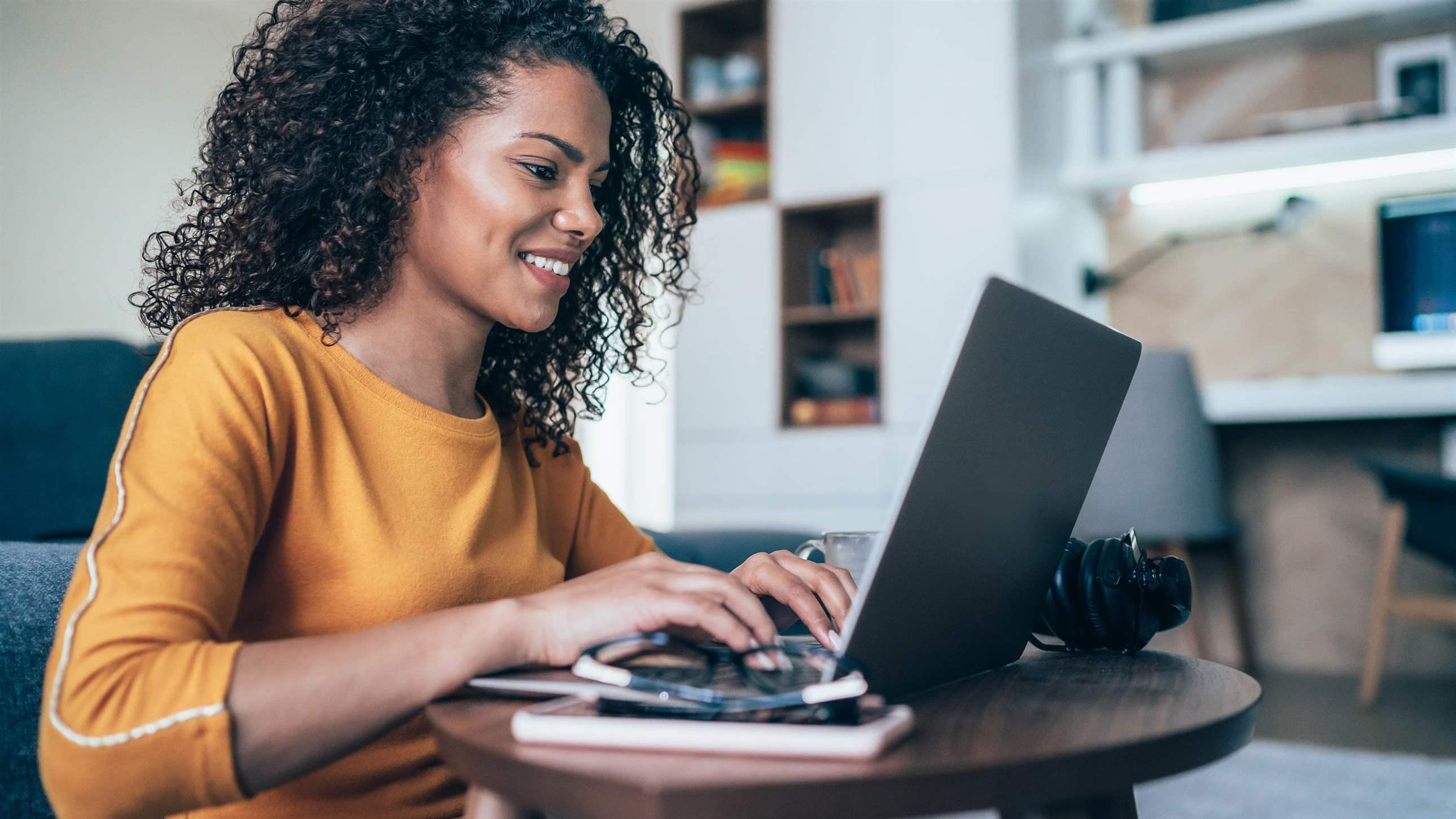 Young modern woman working from home, using laptop in quarantine